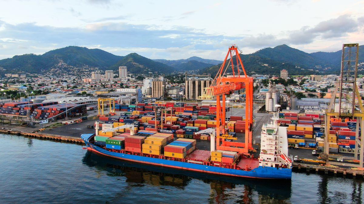 Container ship at a terminal in Port of Spain, Trinidad and Tobago, with gantry cranes loading and unloading cargo.